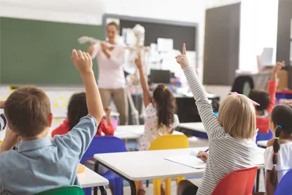 Aula di una scuola con bambini che alzano la mano